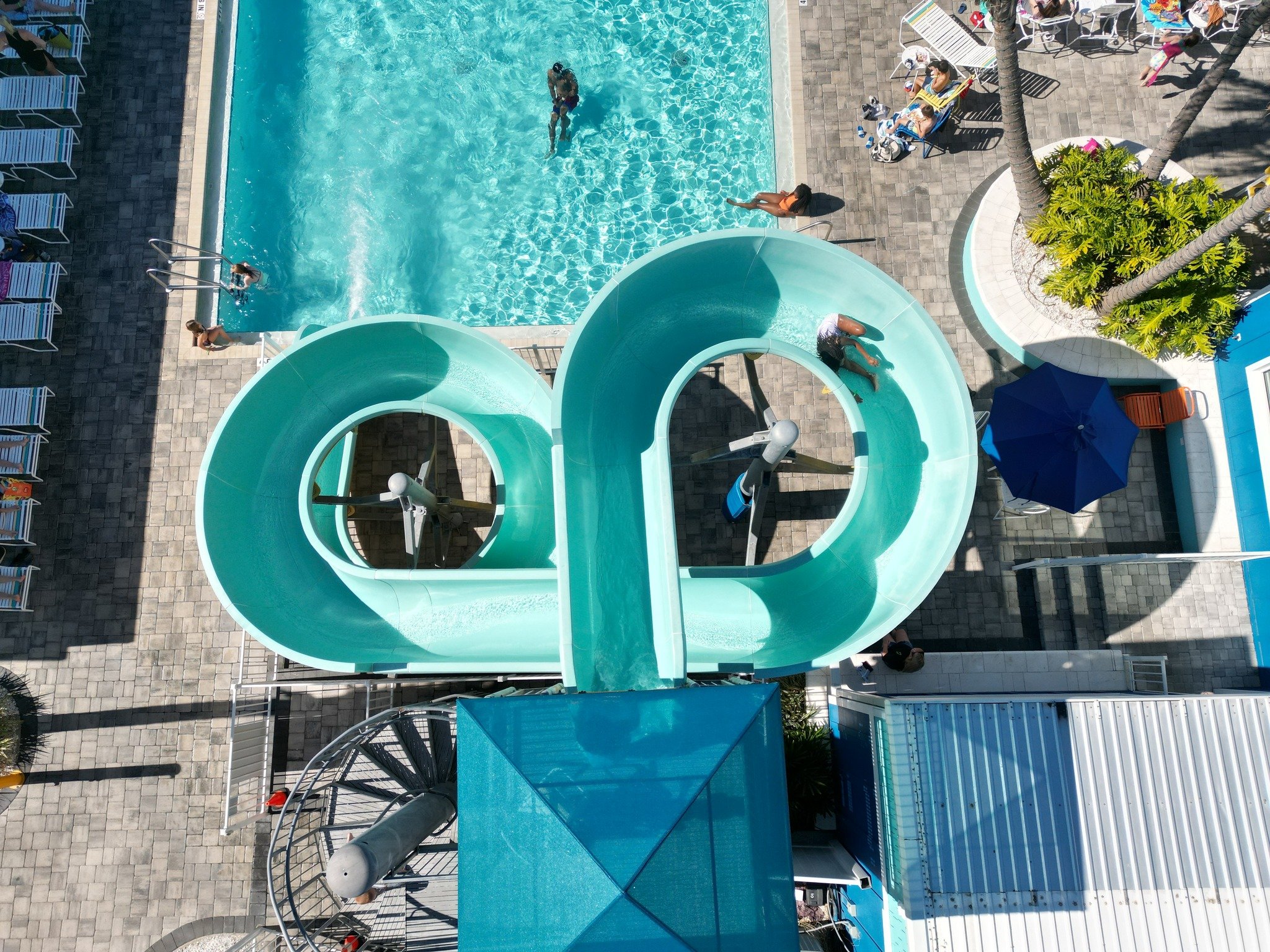 overhead view of water slide that empties into a swimming pool