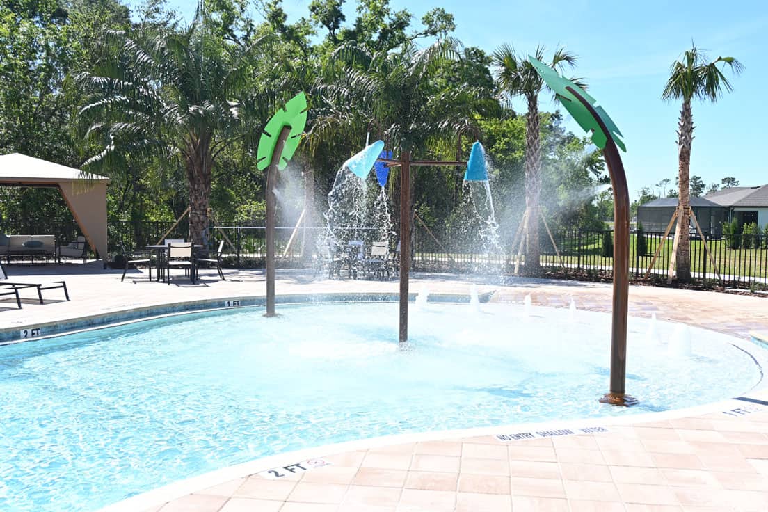 misting leaf water features and dumping buckets in a beach-entry swimming pool