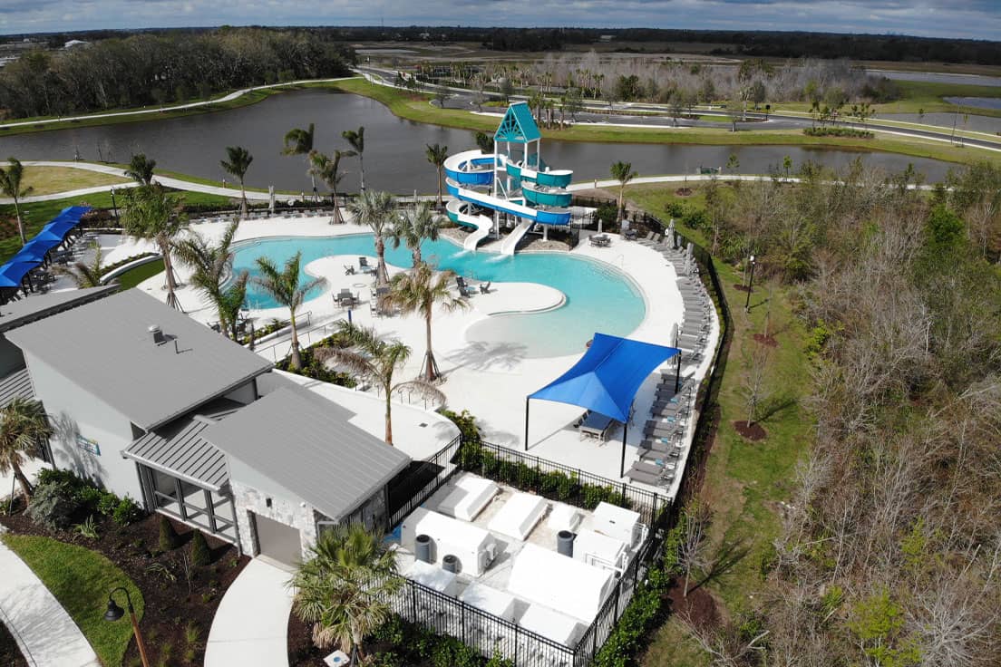 aquatics center with outdoor filtration equipment yard and a double flume waterslide