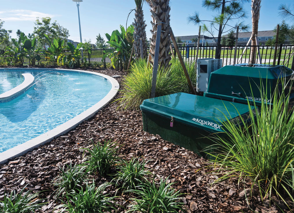 green equipment packs in the landscape next to a lazy river