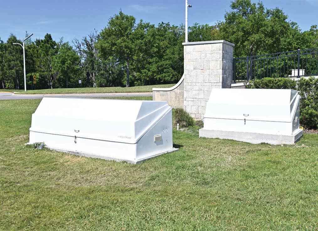 two white fountain equipment packs in a grassy area