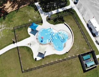 overhead view of splash pad package design with green recirculating filtration system equipment in an gated equipment yard