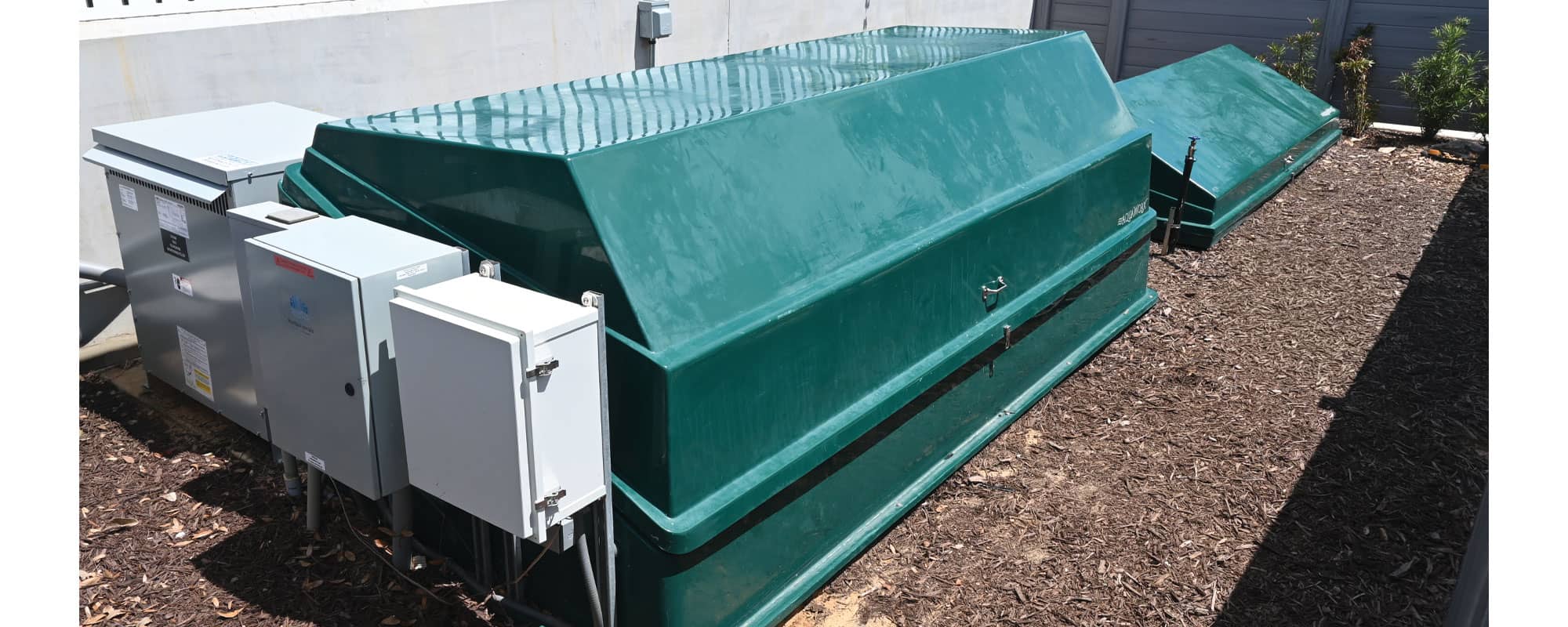 green filtration equipment packs that house the splash pad water management system are located in an outdoor equipment yard