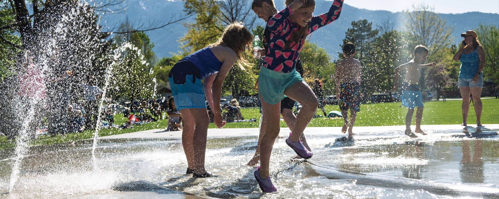 children playing in the splash pads river that surrounds the perimeter of the splash pad