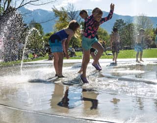 children playing in the splash pads river that surrounds the perimeter of the splash pad