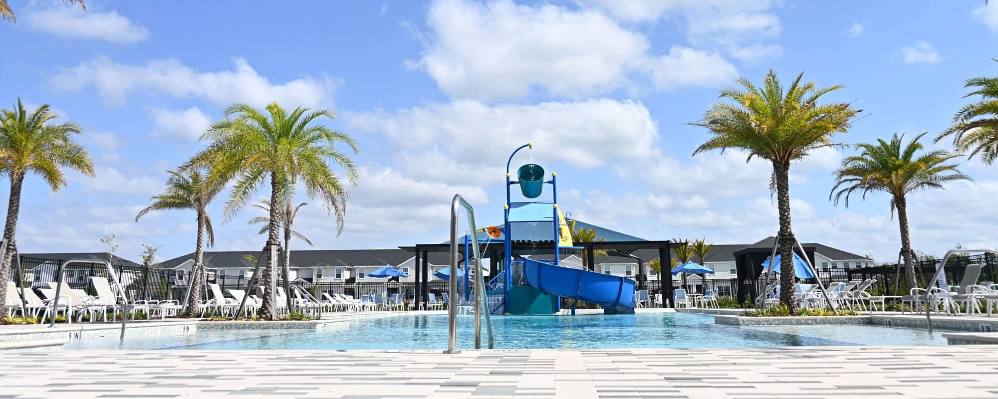 resort-style swimming pool with a multi-level water playset in a tropical environment