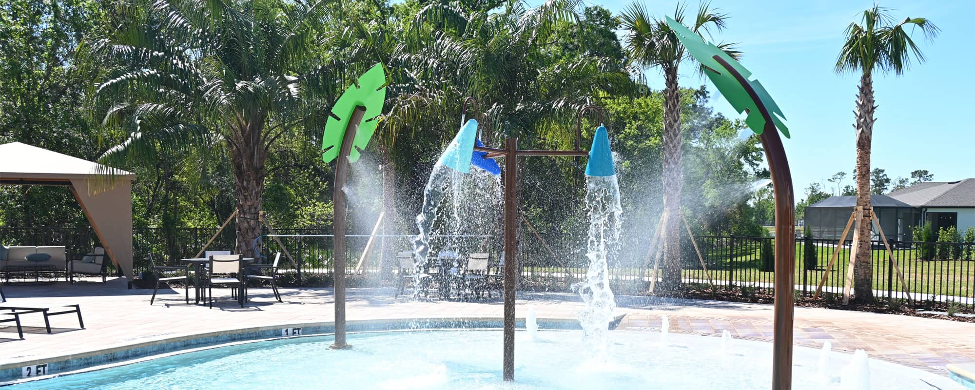 misting palm leaf water features and a three-piece dumping bucket water feature for swimming pool