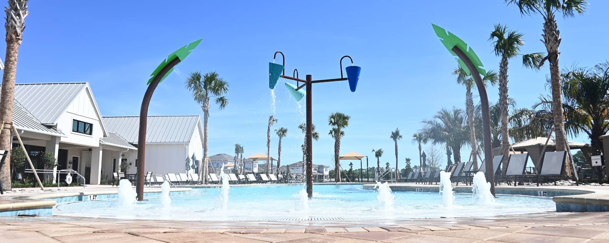 palm tree-themed interactive water features and dumping buckets in a beach-entry swimming pool