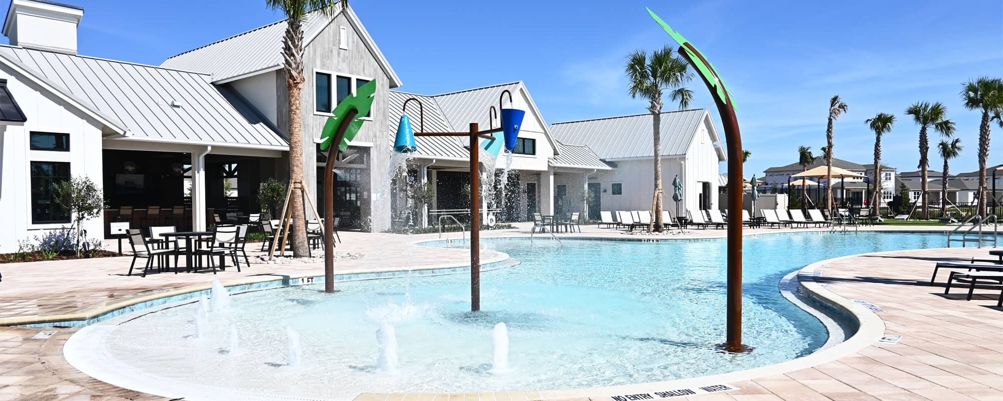 palm tree-themed interactive water features and dumping buckets in a beach-entry swimming pool