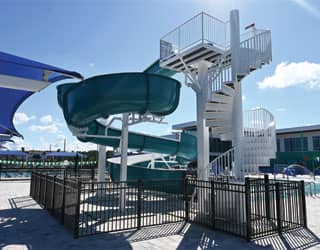 Open flume waterslide with spiral staircase tower