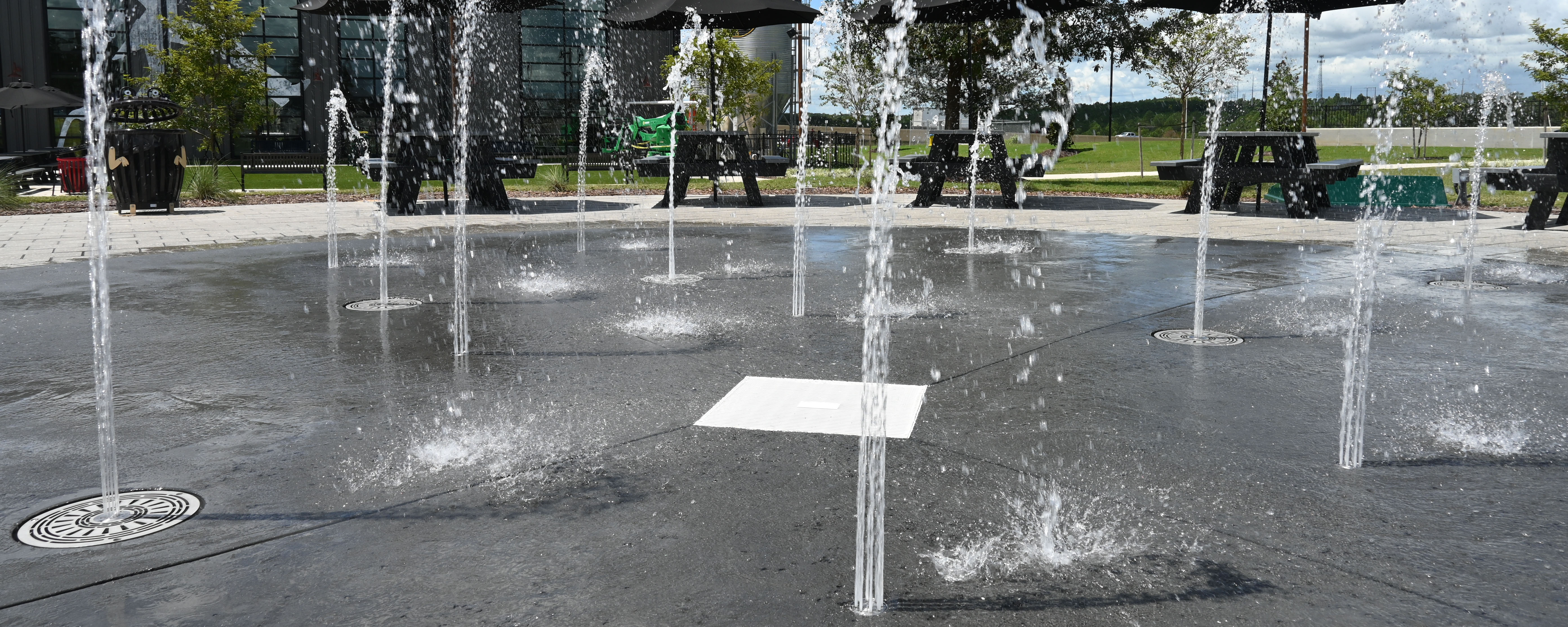 Close-up shot of Fountain in a Can and Aqua Cone ground sprays on splashground